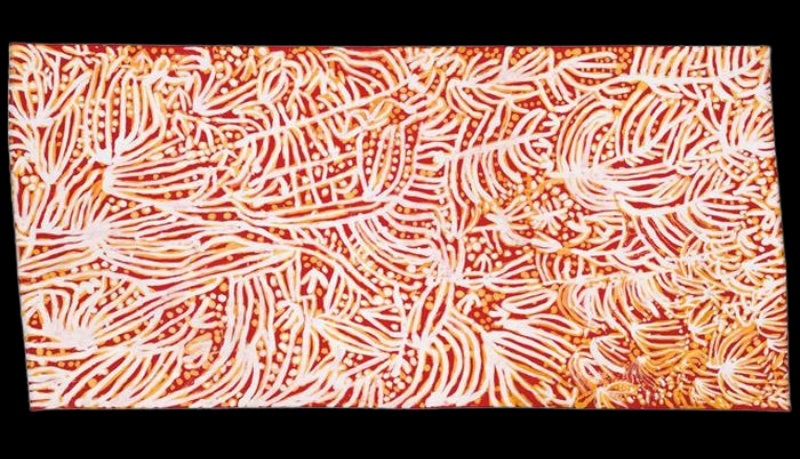 Emily Kame Kngwarreye’s Urapuntja (1987), a silk batik with dense flowing white and pale yellow linear marks and dots across a red-orange ground.