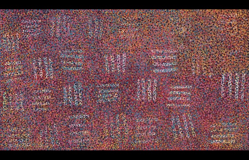 Emily Kame Kngwarreye’s Mourning, 1991, a large horizontal painting densely covered with red, pink, purple, blue, ochre and dark dots, interrupted by repeated pale linear and barred forms.