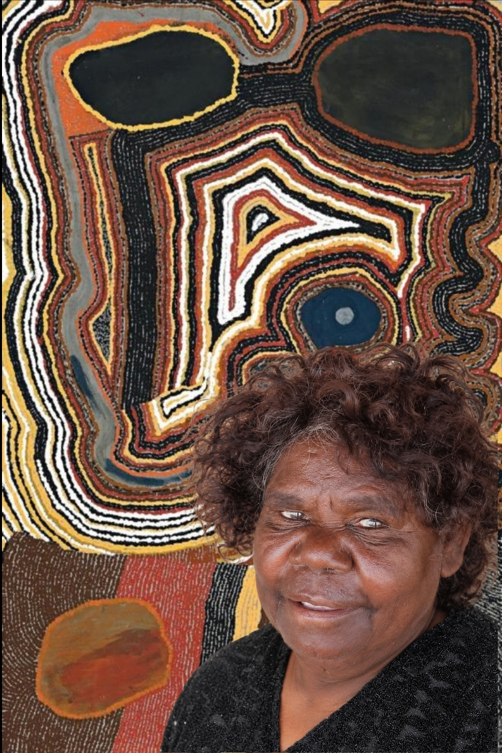 Bai Bai Napangarti, pioneering Balgo Aboriginal artist and senior Kukatja and Ngarti songwoman, pictured against a colourful Western Desert painting.