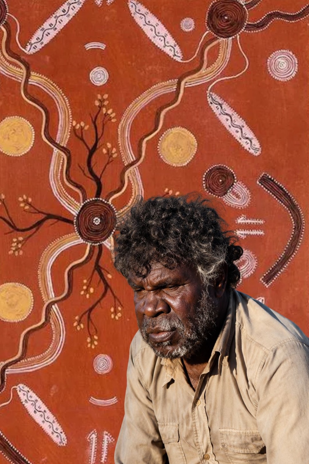 Kaapa Mbitjana Tjampitjinpa – Western Desert Artist Portrait of Kaapa Mbitjana Tjampitjinpa in front of a Western Desert Aboriginal painting featuring concentric circles, ancestral pathways and ceremonial designs.