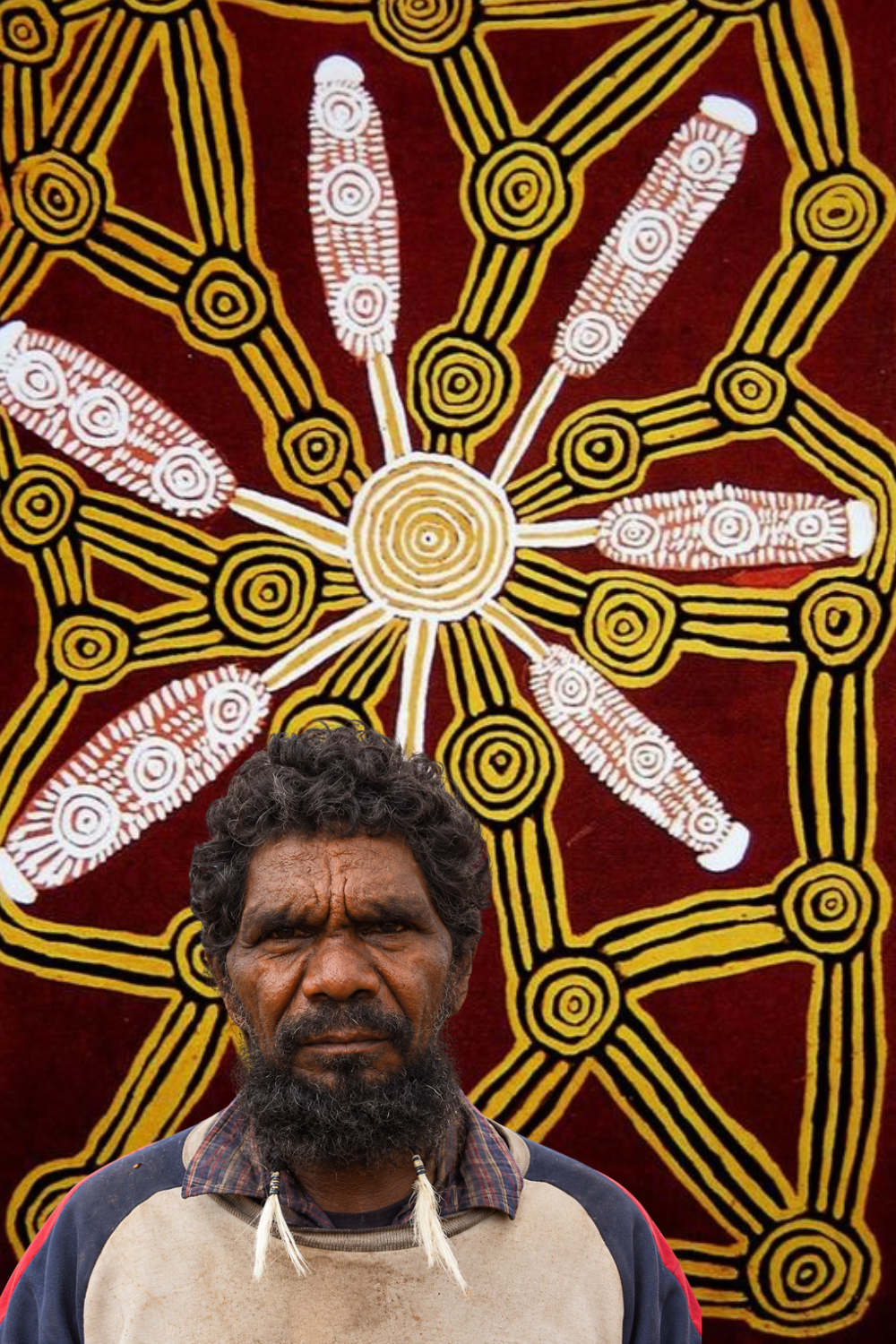 Timmy Payungka Tjapangati – Papunya Artist Timmy Payungka Tjapangati, pioneering Papunya Aboriginal artist, pictured against a Western Desert painting featuring ceremonial designs and concentric circles.