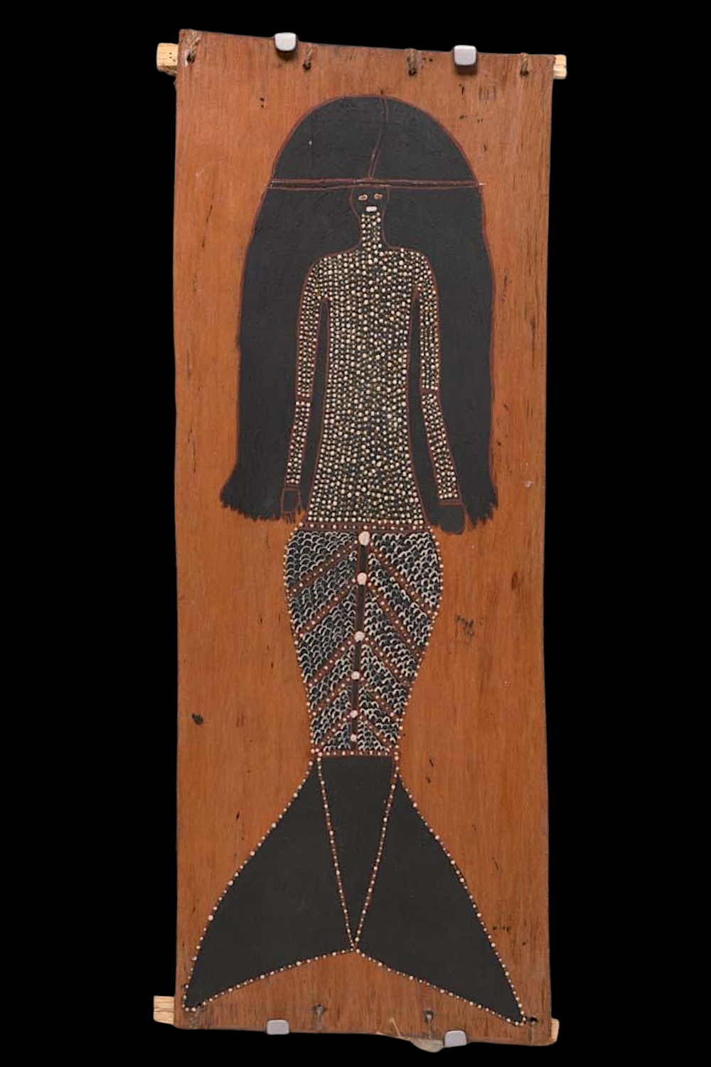 Owen Yalandja bark painting of a Yawkyawk female freshwater spirit with long black hair, a dotted upper body and a fish tail decorated with fine V-shaped scales.